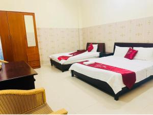 a hotel room with two beds and a desk and a desk at Phát Thịnh Hotel in Ho Chi Minh City
