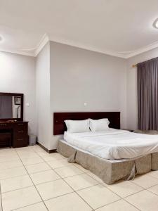 Ḑubāأعمال الهاشم للشقق المخدومة ضبا Al Hashem for Served Apartments的一间卧室配有一张大床和一个梳妆台