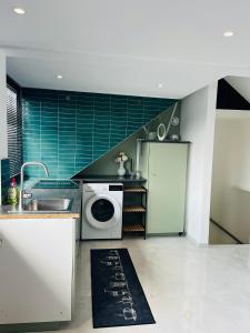 a kitchen with a sink and a washing machine at Stijlvol en comfortabel appartement in rustige wijk in Nijmegen