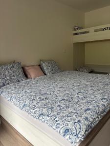 a bed with a blue and white comforter in a bedroom at Apartmán Mateřídouška in Cerny Dul