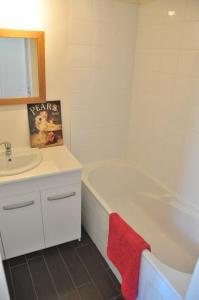 a bathroom with a white tub and a sink and a red towel at Corps de ferme tranquille et familial près de Chambord et de Blois in Séris