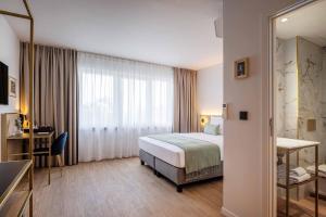 a hotel room with a bed and a desk at Jill Hotel Brussels Centre Midi in Brussels +38 photos
