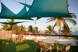 un patio con tavoli, sedie e vista sull'oceano di Hotel Albemarle Galapagos Beachfront a Puerto Villamil