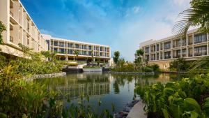 a large building with a river in front of it at Holiday Inn Resort Bintan Lagoi Beach by IHG in Lagoi