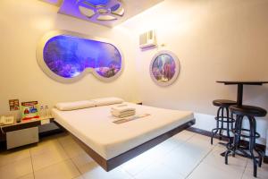 a hospital room with a bed and two bar stools at Astrotel Novaliches in Manila