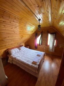 an attic bedroom with a bed in a log cabin at Happy Hikers in Kovačka Dolina +4 photos