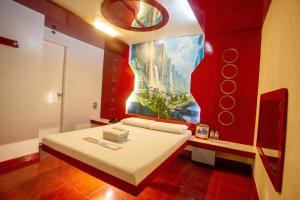 a bedroom with a bed with a painting on the wall at Astrotel Novaliches in Manila +10 photos