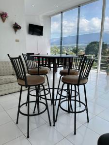a dining room table with chairs and a large window at Villa Kaca 88 in Cinengangirang