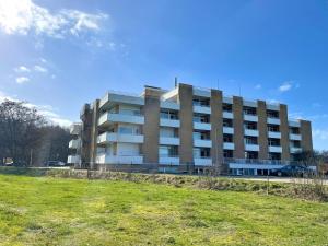 a largeartment building with a field in front of it at Apartmenthaus Frauenpreiss FeWo 60 in Cuxhaven