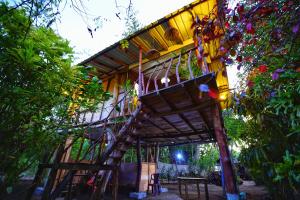 a tree house in the middle of a garden at The Travel Tree Hostel in Sigiriya