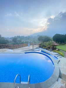a large swimming pool with a view of a mountain at Villa Kaca 88 in Cinengangirang