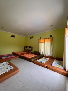 a room with four beds in the corner of a room at Villa Kaca 88 in Cinengangirang