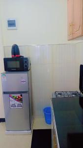 a small kitchen with a refrigerator and a stove at Nadelle Cozy Homes in Bonyunyu