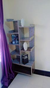 a book shelf with a clock on it in a room at Nadelle Cozy Homes in Bonyunyu