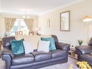 a living room with a leather couch with blue pillows at Princes Gate Cottage in Templeton