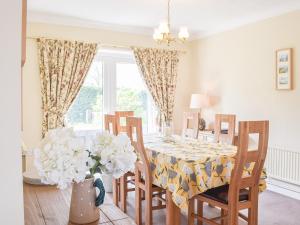 a dining room with a table with a vase of flowers at Princes Gate Cottage in Templeton