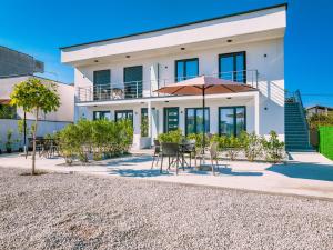 a house with a table and chairs and an umbrella at TaNa's Apartments in Donji Štoj