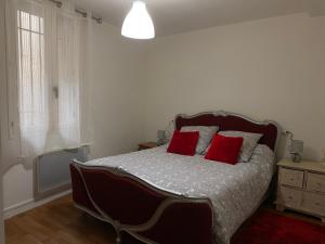 Un dormitorio con una cama grande con almohadas rojas. en Meilleur rapport qualité prix, en Nyons