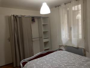 1 dormitorio con cama, ventana y estante en Meilleur rapport qualité prix, en Nyons 1 foto más
