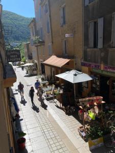 un grupo de personas caminando por una calle con un paraguas en Meilleur rapport qualité prix, en Nyons