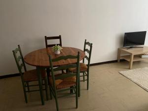 Una mesa de madera con sillas y una mesa con una computadora. en Meilleur rapport qualité prix, en Nyons