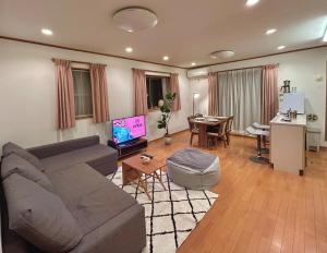 un soggiorno con un divano e un tavolo di AiES新小岩 新小岩站走8分 繁华商店街旁 最大12人 直达机场秋叶原新宿 旅馆内带免费停车场庭院露台 邻公园 a Tokyo