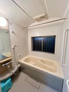 un bagno con vasca e finestra di AiES新小岩 新小岩站走8分 繁华商店街旁 最大12人 直达机场秋叶原新宿 旅馆内带免费停车场庭院露台 邻公园 a Tokyo Altre 56 foto