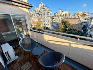 un balcone con 2 sedie e 2 tavoli. di AiES新小岩 新小岩站走8分 繁华商店街旁 最大12人 直达机场秋叶原新宿 旅馆内带免费停车场庭院露台 邻公园 a Tokyo