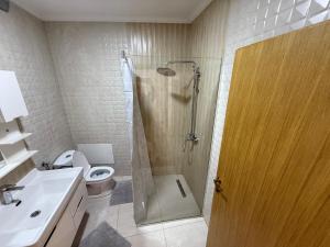 a bathroom with a shower and a toilet and a sink at Cozy apartment in Prizren +14 photos