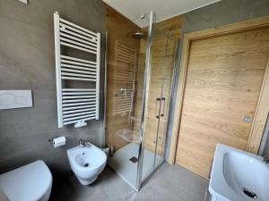a bathroom with a shower and a toilet and a sink at Apartment Val di Rabbi in Rabbi +5 photos