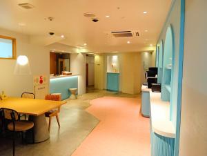 a living room with a table and a kitchen at Nesthotel alt Kawasaki Station in Kawasaki +8 photos
