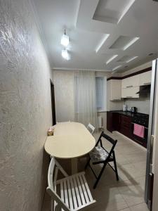 a kitchen with a table and chairs in a room at Spacious Modern Apartment mins drive to City Center in Chişinău