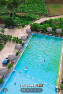 an overhead view of a large swimming pool with people in it at Lộc Phát hotel Mộc Châu in Bả Duộc