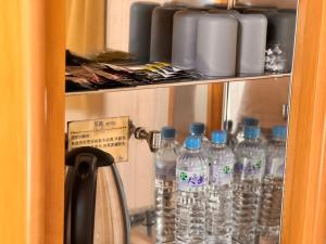 a bunch of bottles of water on a shelf at I Live Motel in Kaohsiung