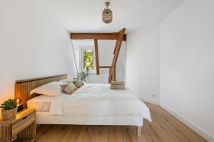 a white bedroom with a bed and a window at De Hill Rotterdam in Rotterdam