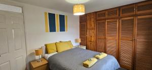 ein Schlafzimmer mit einem Bett mit gelben Kissen darauf in der Unterkunft OG Stays III- 6bedroom house- sleeps 9persons, Near Nissan & Stadium of Light, free parking in Pallion