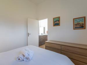 a white bedroom with towels on a bed at Ty Ker by Madame Est Servie in Pleumeur-Bodou