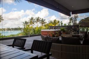 a patio with chairs and tables and a view of the ocean at Beachfront Penthouse 3 bedrooms - Grand Baie Mauritius in Grand Baie