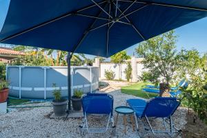 a patio with two blue chairs and an umbrella at Relaxrooms in Lefkímmi