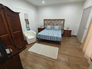 a bedroom with a bed and a chair at La dimora di Lorenzo in Giurdignano