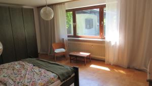 a bedroom with a bed and a window and a chair at Familiennest Vogelwuid in Seebruck +29 photos