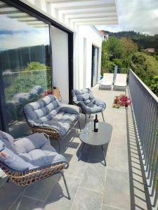 a patio with chairs and a table on a balcony at CASA PANORAMA SOL- NEW VILLA WITH HEATED SALTWATER POOL and FANTASTIC SEA VIEW in Ponta do Sol