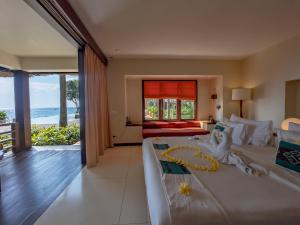 a bedroom with a bed and a view of the ocean at Qunci Villas Resort in Senggigi