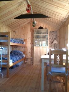 a room with two bunk beds and a table and a desk at Countrycabin Bergslagen stuga in Ramsberg