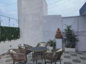 a patio with a table and chairs and a statue at Gurgaon 21 Tonic & Twinkle in Gurgaon