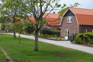 un árbol en el césped delante de una casa en Dunopark Villa, en Oostkapelle