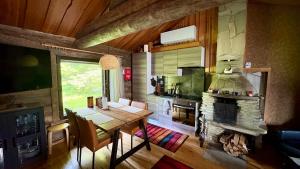 a kitchen and dining room with a table and a fireplace at Holiday Hopukka in Luosto