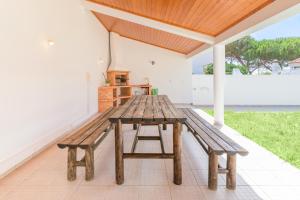 a wooden picnic table sitting on a patio at Casa Nelson e Esperanca in Vila Nova de Milfontes