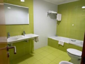 zielona łazienka z toaletą i umywalką w obiekcie Hostal Restaurante Pinarejo w mieście A Lanzada