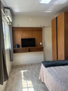 Un dormitorio con una cama y un televisor de pantalla plana. en Apartamento a beira do Rio Preguiça, en Barreirinhas
